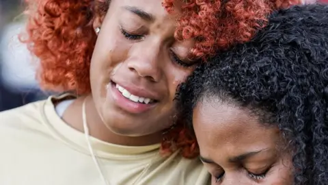 EPA Two girls cry at a vigil